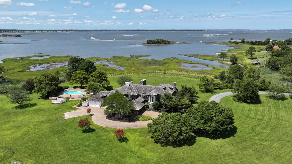 Aerial view of the estate, its lawns and the pool, with the marsh and the bay around it