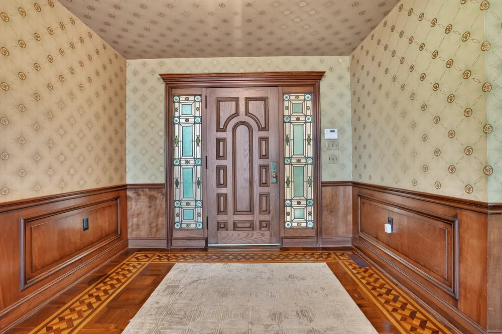 The front entry, with a carved wood door flanked by stained-glass panels