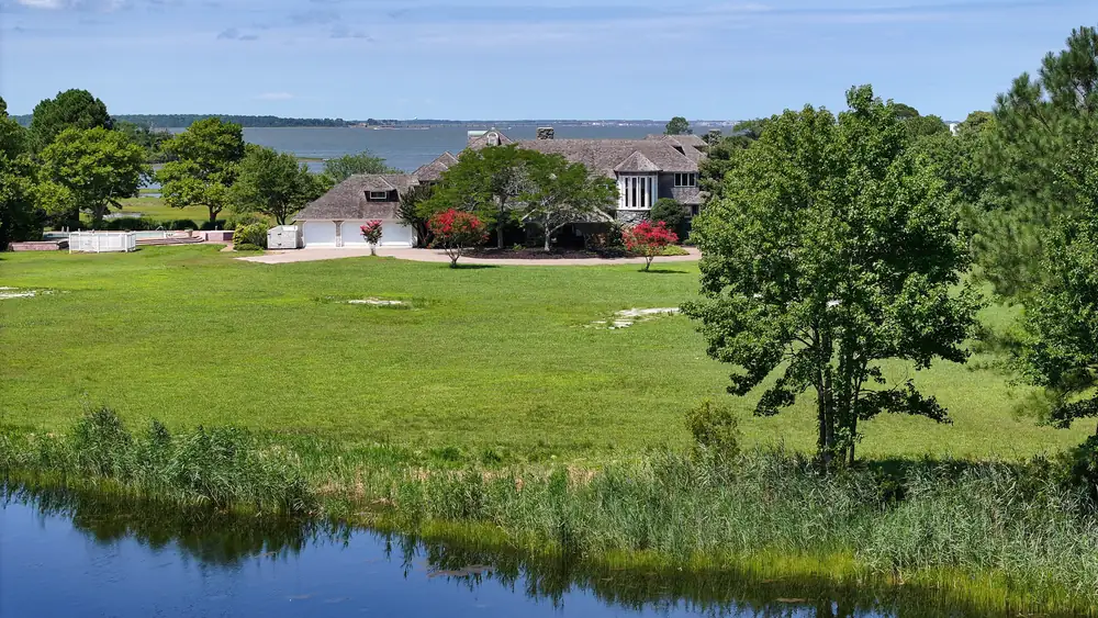 The pond in the foreground, with the lawn and the house across the water
