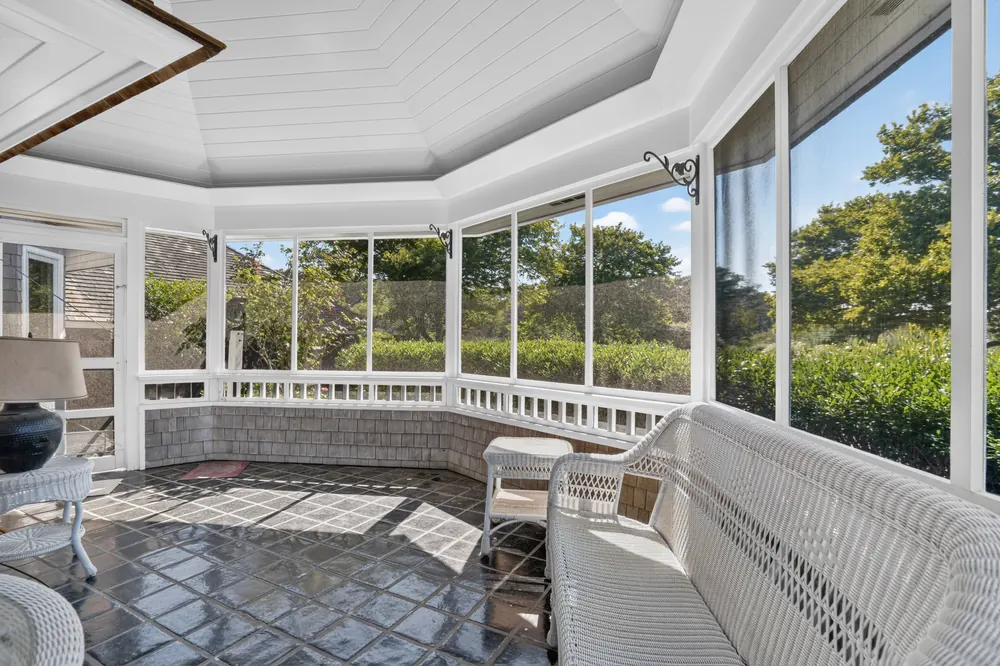 The round screened porch with wicker seating and views over the lawn