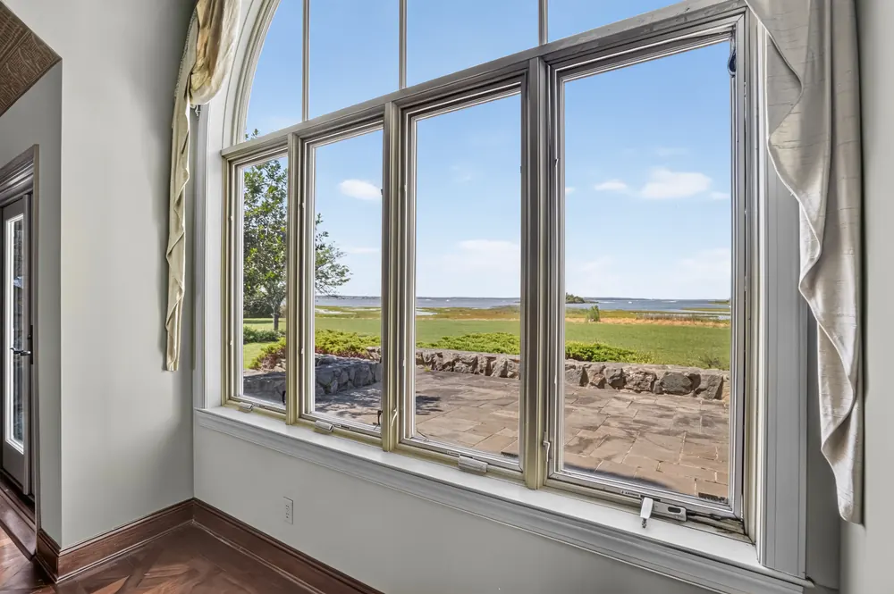 A tall window framing the marsh and the bay